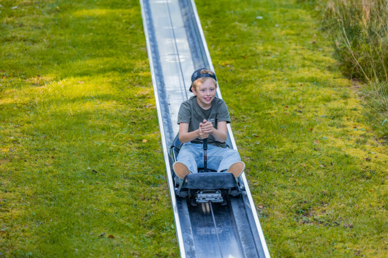 Sommerrodelbahn Winterberg mit Kind auf der Rodelstrecke und rasanter Freizeitattraktion im Sauerland.